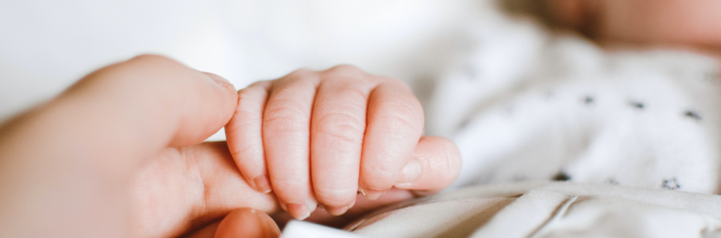 baby holding a mother's hand