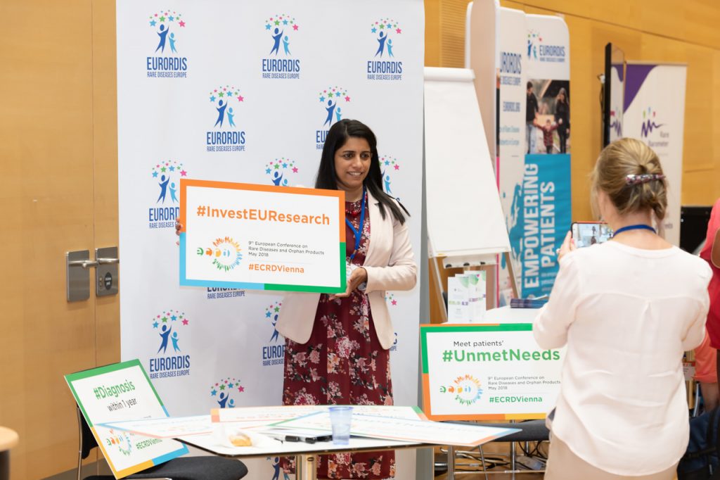 A woman holding a poster saying #InvestEUResearch at ECRD 2018