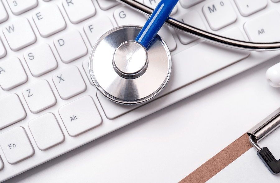 Closeup of a stethoscope, a clipboard, and a keyboard.