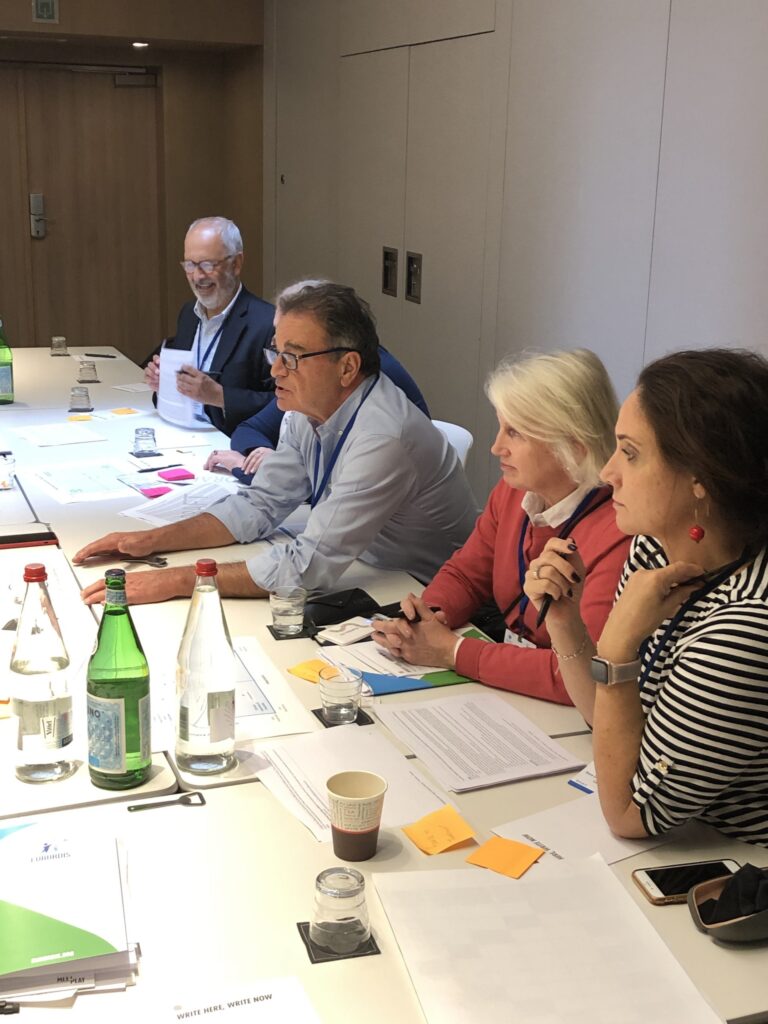 Meeting members on one side of the table engaged in discussion